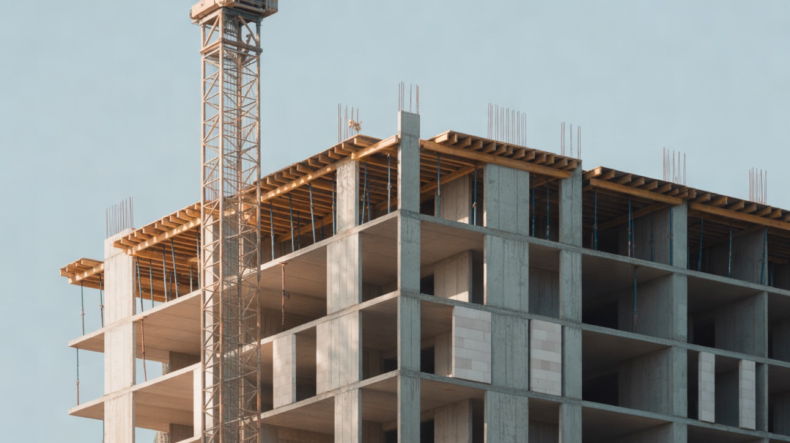 Revit Used For: a mid rise building under construction with a tower crane, a concrete frame and the first facade panels installed