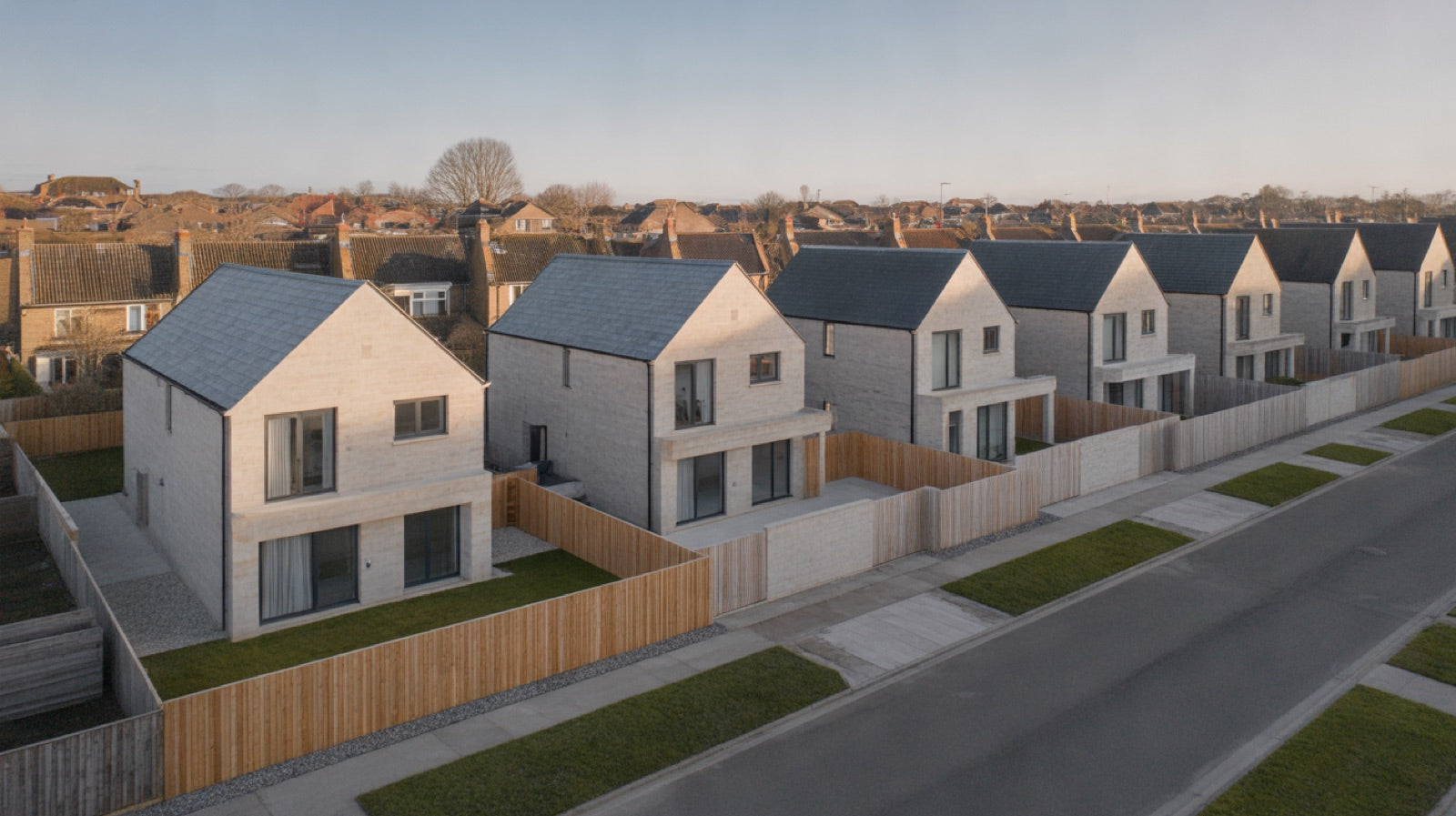 Setback in Building Design: oblique aerial view of a suburban street of detached houses set back behind uniform front gardens and driveways